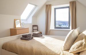 a bedroom with a bed with two towels on it at 3 Carbost in Tole