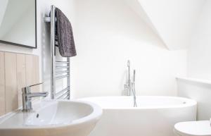 a white bathroom with a sink and a tub at 3 Carbost in Tole +38 photos