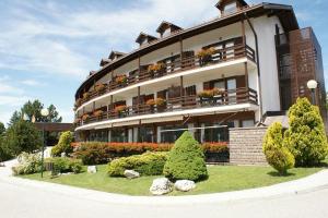 a large building with flowers and plants in front of it at Dolomiti Panorama - 3 Rooms in Carano