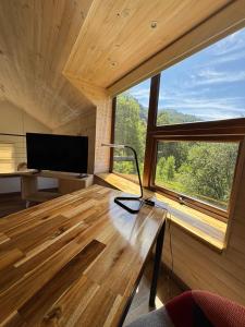a room with a desk and a large window at Refugio entre Montañas - Malalcahuello in Malalcahuello