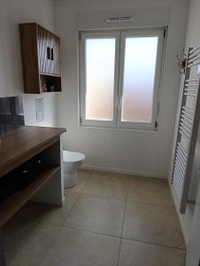a white bathroom with a toilet and two windows at La Pause Loonoise in Loon-Plage +9 photos