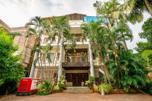 an old building with palm trees in front of it at Greenland Premium Hotel in Bhubaneshwar