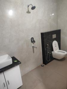 a bathroom with a shower with a toilet and a sink at Greenland Premium Hotel in Bhubaneshwar +43 photos