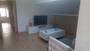 a living room with a tv and a white table at Les Deux Chambres Aucamville in Aucamville