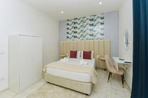 a bedroom with a bed and a desk and a table at Guest House Partenope in Naples