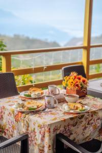 a table with plates of food and cups on it at Chalet Ecoturismo La Nohelia in Jericó