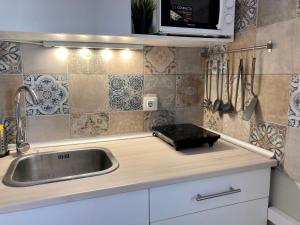 a kitchen counter with a sink and a microwave at Sea Breeze Alojamientos in Barbate +70 photos