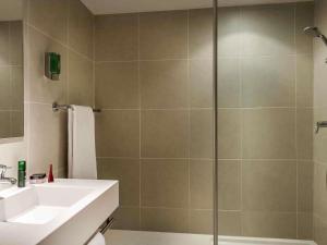 a bathroom with a sink and a shower at AppartHotel Mercure Paris Boulogne in Boulogne-Billancourt