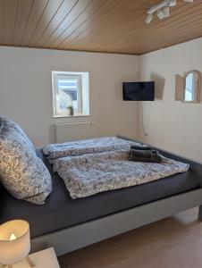 a bedroom with a bed with a tv on the wall at Drive & Dream Nürburgring in Drees