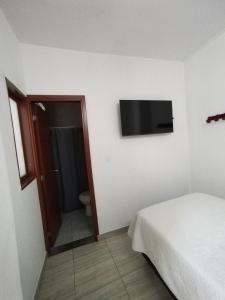 a bedroom with a bed and a television on the wall at Bohemia Hotel in Tunja