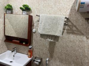 a bathroom with a sink and a mirror and towels at Therese Home in Ngor