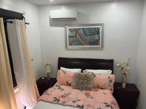 a bedroom with a bed with pink sheets and a painting at Therese Home in Ngor