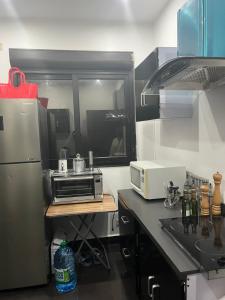 a kitchen with a refrigerator and a microwave at Therese Home in Ngor +11 photos