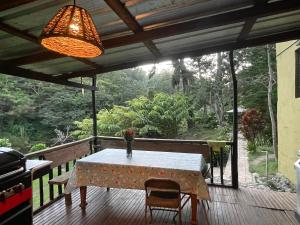 a table on a deck with a view of a forest at Arroyo Frío River Lodge in Arroyo Frío