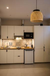 a kitchen with white cabinets and a chandelier at Canoa Studio Vlc & Free filtered drinking water in Valencia +33 photos