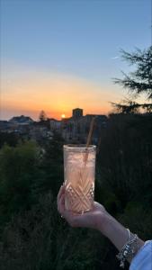 a person holding up a drink with a straw at Logis Hôtel de la Bruyere in Pouzauges