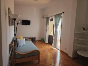 a living room with a chair and a sliding glass door at Aparthotel Santa Maria Beach in Santa Maria