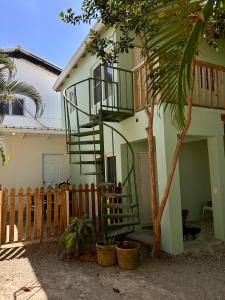 a house with a spiral staircase next to a tree at Oasis Cabarete Guesthouse in San Felipe de Puerto Plata