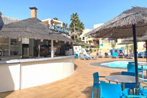 a resort with a pool and tables and chairs and umbrellas at BLUESEA Costa Teguise Gardens in Costa Teguise