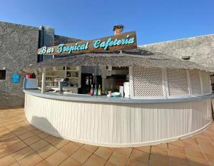 a bar with a sign on top of a building at BLUESEA Costa Teguise Gardens in Costa Teguise
