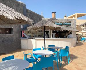 a patio with tables and chairs and an umbrella at BLUESEA Costa Teguise Gardens in Costa Teguise