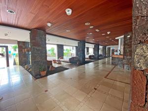 a large lobby with a stone wall and wood ceilings at BLUESEA Apartamentos Callao Garden in Callao Salvaje