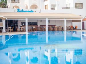 a swimming pool with blue water in front of a hotel at BLUESEA Apartamentos Callao Garden in Callao Salvaje +16 photos