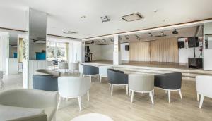 a dining room with white chairs and a bar at BLUESEA Lagos de Cesar in Puerto de Santiago
