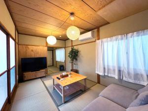 a living room with a couch and a table at SAUNA HOUSE Yutagawa in Tsuruoka