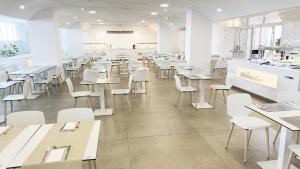 an empty restaurant with tables and white chairs at BLUESEA Lagos de Cesar in Puerto de Santiago +14 photos