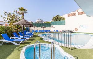 a pool at a hotel with blue chairs and an umbrella at BLUESEA Montevista Hawai in Lloret de Mar