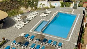 an overhead view of a swimming pool with chaises and chairs at BLUESEA Montevista Hawai in Lloret de Mar