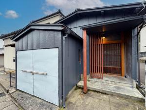 a black house with a garage in the street at SAUNA HOUSE Yutagawa in Tsuruoka