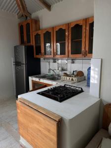 a kitchen with a stove top oven next to a refrigerator at Oasis Cabarete Guesthouse in San Felipe de Puerto Plata +12 photos