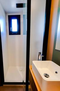 a bathroom with a white sink and a shower at Prestige Chalet 50 in Rivières +9 photos