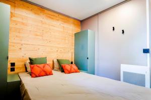 a bedroom with a bed with orange and green pillows at Prestige Chalet 50 in Rivières