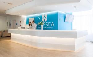 due persone in piedi al bancone di uno studio dentistico di BLUESEA Gran Playa a Sa Coma