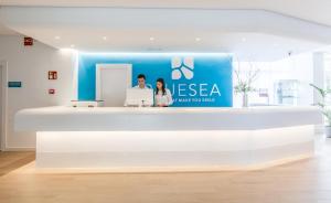 due persone in piedi alla reception di un ufficio di BLUESEA Gran Playa a Sa Coma