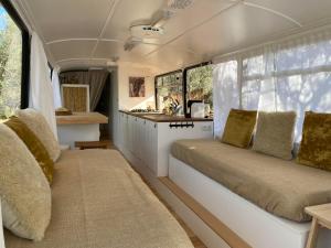 an interior view of a caravan with two seats and a kitchen at Glamping Algarve Olive Tree Lodge in Nora