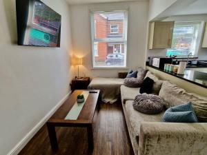 a living room with a couch and a coffee table at Incredible Private Rooms All with Private Bathrooms in a Fully Serviced House next to City Centre with Free Parking in Coventry