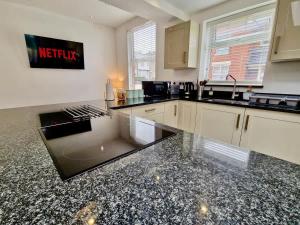 a kitchen with black and white granite counter tops at Incredible Private Rooms All with Private Bathrooms in a Fully Serviced House next to City Centre with Free Parking in Coventry