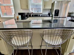 two chairs sitting at a counter in a kitchen at Incredible Private Rooms All with Private Bathrooms in a Fully Serviced House next to City Centre with Free Parking in Coventry