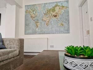 a living room with a couch and a map on the wall at Incredible Private Rooms All with Private Bathrooms in a Fully Serviced House next to City Centre with Free Parking in Coventry