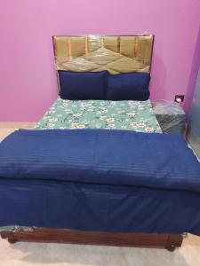 a bed with a blue comforter and blue pillows at Sariyal Homestay in Kandikhal