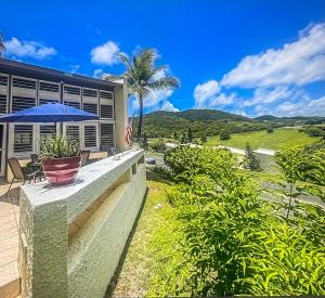 a house with a patio with a blue umbrella at Tropical Oasis in Christiansted