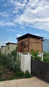a small house with a refrigerator in front of it at Em Cá Gỗ Farmstay in Phước Bình