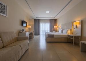 a large hotel room with a bed and a couch at Maritim Antonine Hotel & Spa in Mellieħa