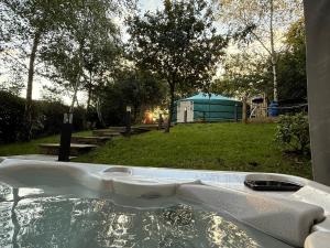 a jacuzzi tub in a yard with a tent at Yurt with Hot Tub near Hartington, Peak District in Buxton