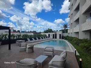 a patio with chairs and a swimming pool on a building at QUEEN ANGEL condo in Cozumel