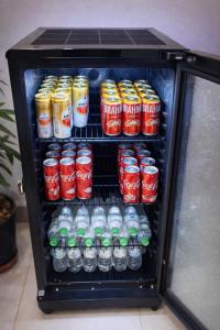 a refrigerator filled with cans and bottles of soda at Palace Hotel in Anápolis